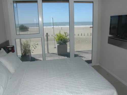 1 dormitorio con cama y vistas a la playa en La Medusa Valeria en Valeria del Mar