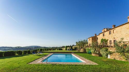 a swimming pool in a yard next to a building at Ormanni nel Chianti Classico in Barberino di Val dʼElsa