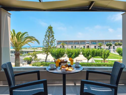 a table with fruit on a balcony with a view of a building at Solimar Aquamarine Resort in Gerani Chanion