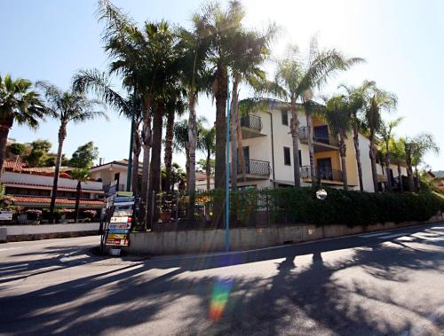 a bus parked in front of a building with palm trees at Hotel Il Ceppo in Agropoli