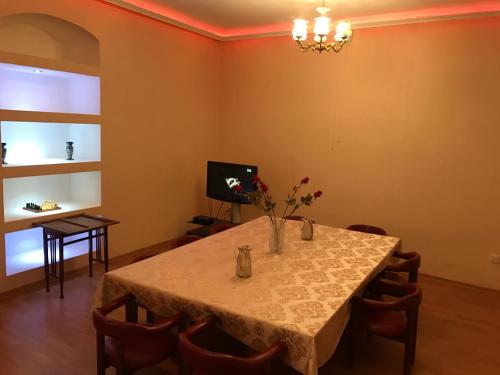 a dining room with a table with flowers on it at Beaming_House in Sheki