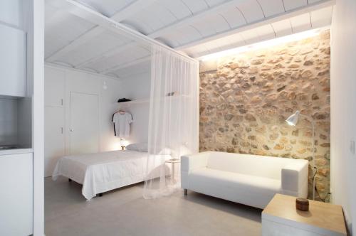 a white bedroom with a bed and a couch at Estudio Casco Antiguo Inmomart in Peniscola