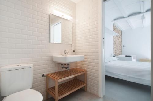 a bathroom with a sink and a toilet and a bed at Estudio Casco Antiguo Inmomart in Peniscola