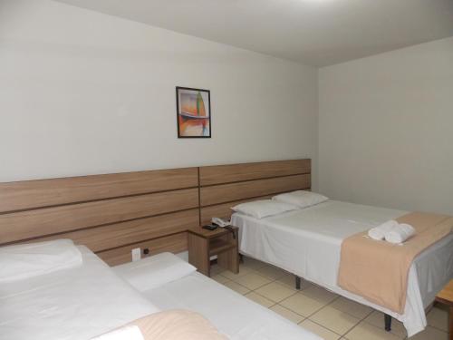 a hotel room with two beds and a mirror at Hotel Mattes in Joinville