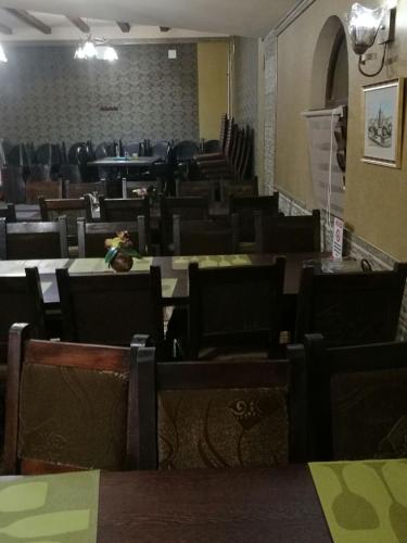 an empty dining room with tables and chairs at Pensiunea Dely_Cios in Vălenii de Munte