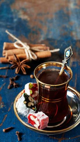 a cup of tea with a spoon in it on a plate at Pensiunea Dely_Cios in Vălenii de Munte