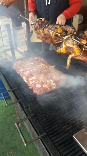 a person is cooking meat on a grill at Pensiunea Dely_Cios in Vălenii de Munte