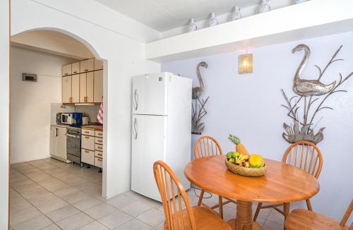 a kitchen with a table with a bowl of fruit on it at Royal Palm Holiday Apartment in Méro