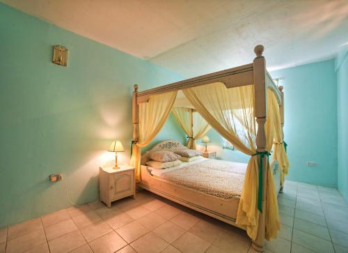 a bedroom with a canopy bed and a night stand at Royal Palm Holiday Apartment in Méro