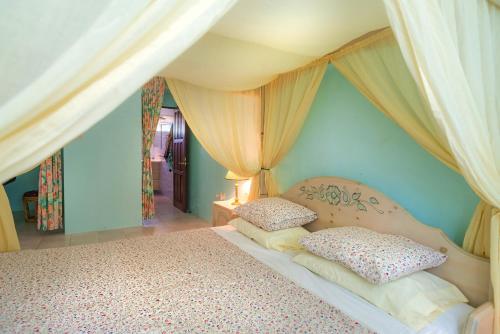 a bedroom with a canopy bed with two pillows at Royal Palm Holiday Apartment in Méro