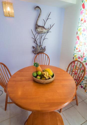a wooden table with a bowl of fruit on it at Royal Palm Holiday Apartment in Méro