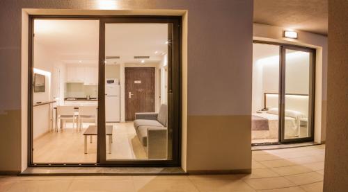 a living room with a sliding glass door leading to a bedroom at ApartHotel Playa Oliva in Oliva