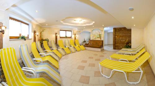 a group of yellow chairs and tables in a waiting room at Jagdhof in Grossarl