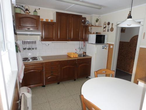 cocina con armarios de madera y nevera blanca en Chata Bludička, en Deštné v Orlických horách