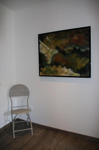 a chair in a room with a painting on the wall at La carpe diem in Bédoin