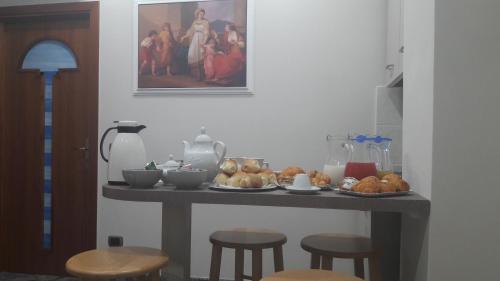 庞贝B&B Cornelia的一张桌子上放着一盘面包和几张凳子。