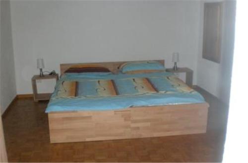 ein Bett mit einem Holzrahmen in einem Schlafzimmer in der Unterkunft Casa Arcuri in Giumaglio