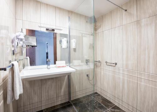 a bathroom with a sink and a shower at Ramada Hotel by Wyndham Edirne in Edirne