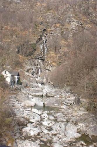 a rocky mountain with a house and a river at Casa Arcuri in Giumaglio