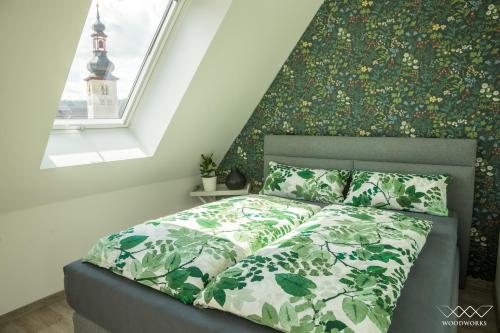 a bedroom with a bed with a green bedspread and a window at TeigenHeim in Rüdesheim am Rhein