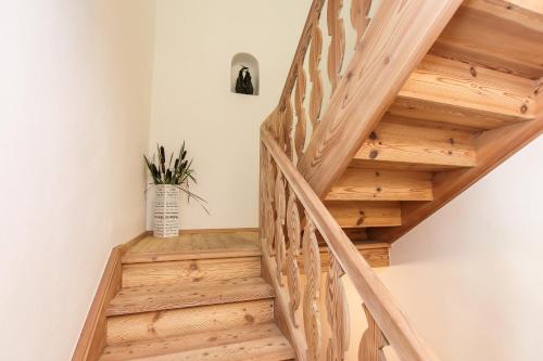 a wooden staircase in a house with a potted plant at Chalet Grossglockner in Fusch an der Glocknerstraße