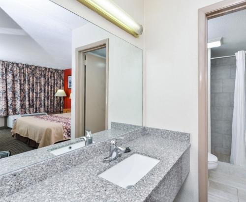 y baño con lavabo y espejo. en Americas Best Value Inn - Goodlettsville, en Goodlettsville