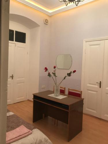 a room with a table with a vase with flowers on it at Beaming_House in Sheki