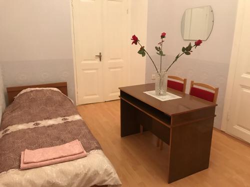 a room with a table with a vase with flowers on it at Beaming_House in Sheki