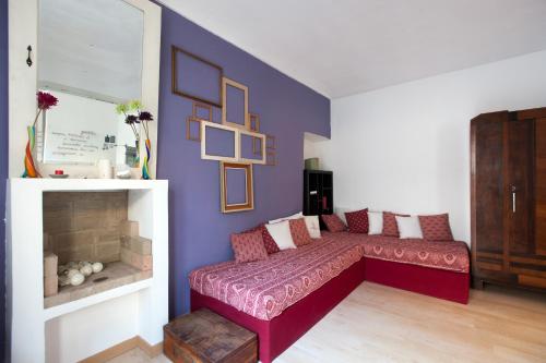 トリノにあるCit Ma Bel Studio Flatの赤いソファと紫の壁が備わるリビングルーム