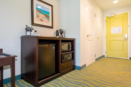 a room with a tv and a yellow door at Edge Hotel Clearwater Beach in Clearwater Beach
