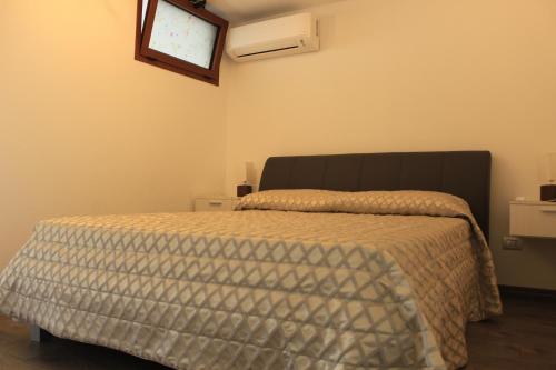 a bedroom with a bed with a comforter on it at Vista Mare in Lanusei