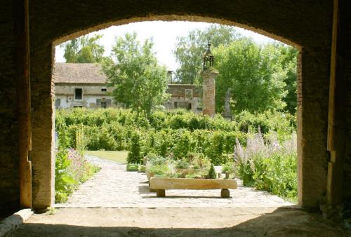 a stone archway with a bench in a garden at Chateau Třebešice in Kutná Hora