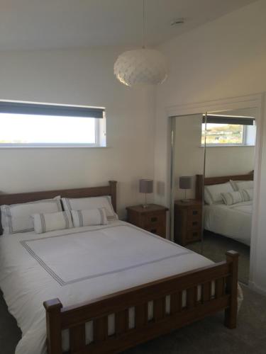 a bedroom with a large bed and a mirror at 35 Newvalley in Stornoway