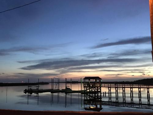 a dock on a lake with a cloudy sky at Steinhatchee River Inn and Marina in Steinhatchee
