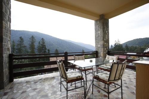 eine Terrasse mit einem Tisch und Stühlen auf dem Balkon in der Unterkunft Roberto Hotel in Sinaia