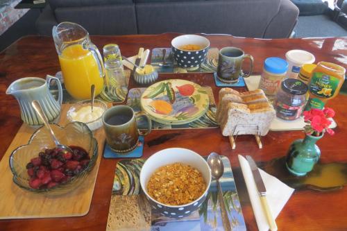 a table with breakfast foods and drinks on it at Koru Beachfront Holiday Cabins & Hot Tub in Barrytown