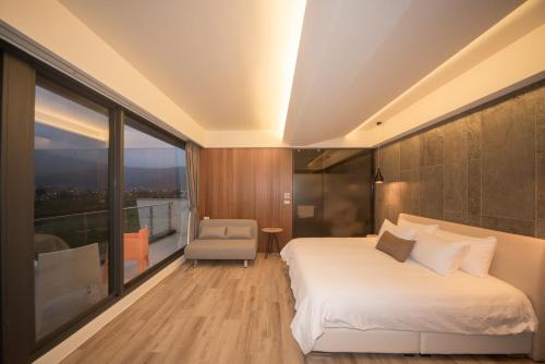 a bedroom with a bed and a chair and a window at sunlight mound in Yuanshan