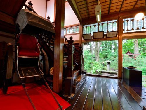 a living room with a red chair and a window at Syohoen in Daisen