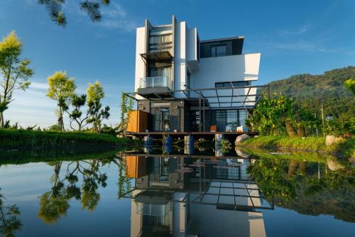 una casa en el agua con su reflejo en sunlight mound, en Yuanshan