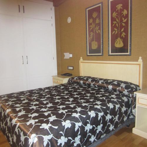 1 dormitorio con edredón blanco y negro en una cama en Hotel Iru-Bide en Lumbier