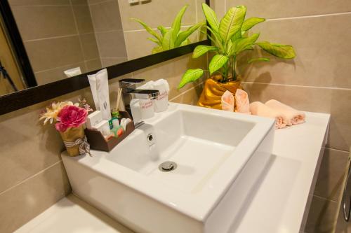 a white sink in a bathroom with flowers on it at Amverton Heritage Resort in Malacca