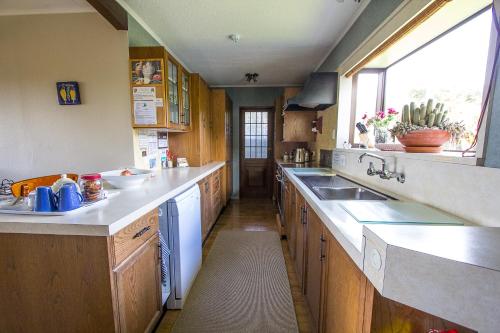 a kitchen with wooden cabinets and a sink and a window at Kowhai Lane Lodge in Half-moon Bay