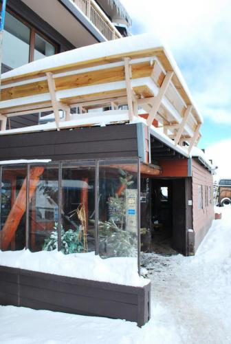 a building with a balcony on top of it in the snow at Hotel HF in Farellones