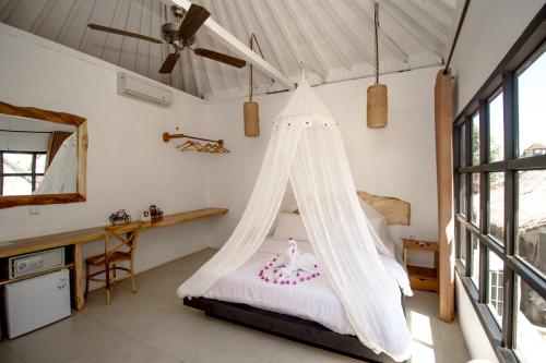a bedroom with a bed with a mosquito net at Gili Breeze Tropical Bungalows in Gili Trawangan