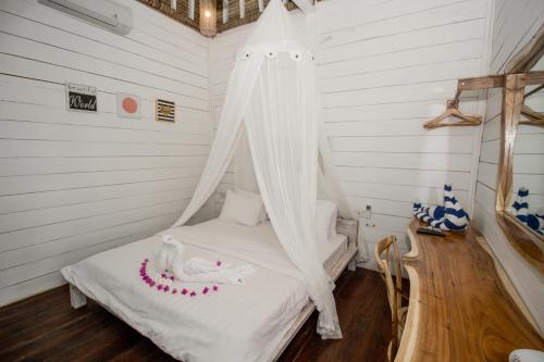 a bedroom with a bed with a mosquito net at Gili Breeze Tropical Bungalows in Gili Trawangan