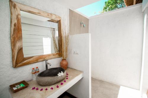 y baño con lavabo y espejo. en Gili Breeze Tropical Bungalows, en Gili Trawangan