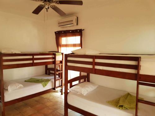 two bunk beds in a room with a ceiling at Hotel Maya Jade in Monterrico