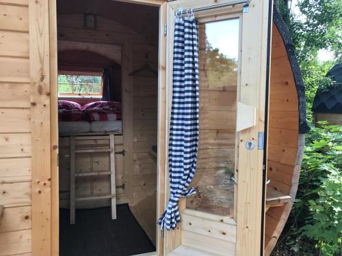 uma porta de uma sauna com uma cama em Schlaffass - Schlafen im Holzfass em Tattendorf