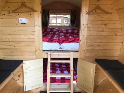 um quarto com uma cama e uma escada numa cabina em Schlaffass - Schlafen im Holzfass em Tattendorf