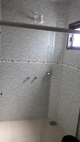 a shower with a glass door in a bathroom at Chalé da Selma I (Isaías) in Alto Paraíso de Goiás